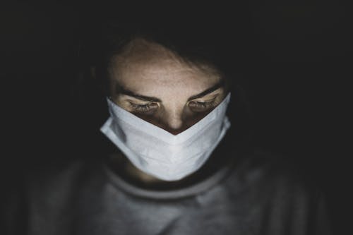 Close-Up Shot of a Person Wearing Face Mask in the Dark