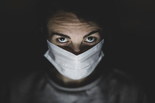 Free Man Wearing Face Mask In A Dark Room Stock Photo