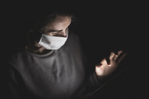 Close-Up Shot of a Person Wearing Face Mask in the Dark