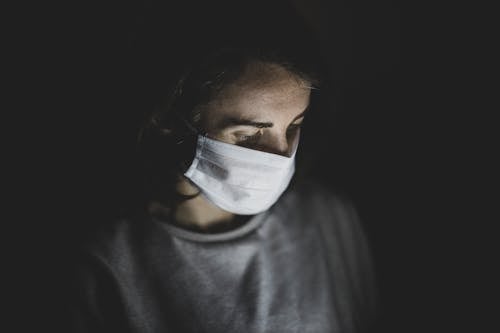 Free Person in Gray Crew Neck Shirt Wearing White Face Mask Stock Photo