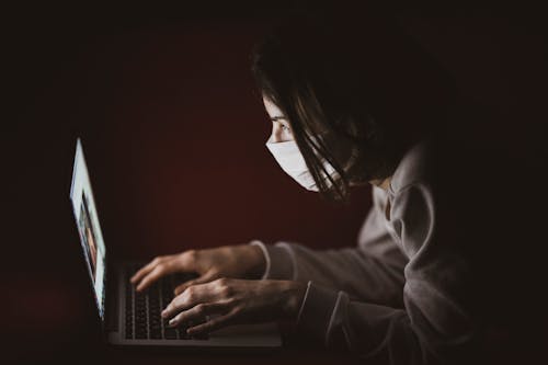 Close-Up Shot of a Person Wearing Face Mask in the Dark