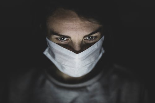 Free Man Wearing Face Mask In A Dark Room Stock Photo