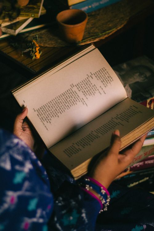 Free A person reading a book indoors, creating a warm and cozy atmosphere. Stock Photo