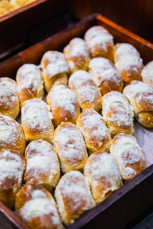 Free A tray of deliciously golden sweet rolls topped with powdered sugar, freshly baked. Stock Photo