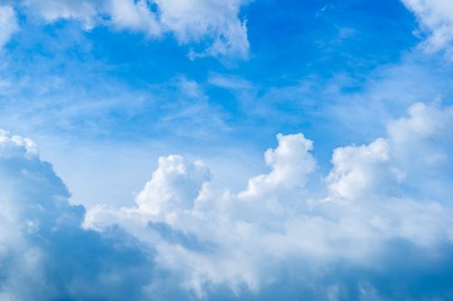 Free A vibrant blue sky filled with fluffy white clouds on a clear, sunny day. Stock Photo