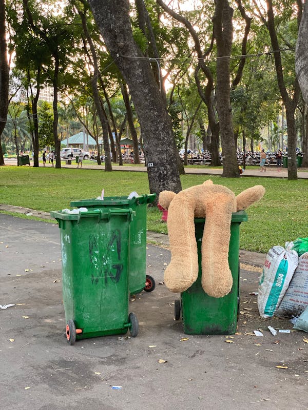 Dirty trash containers near green park