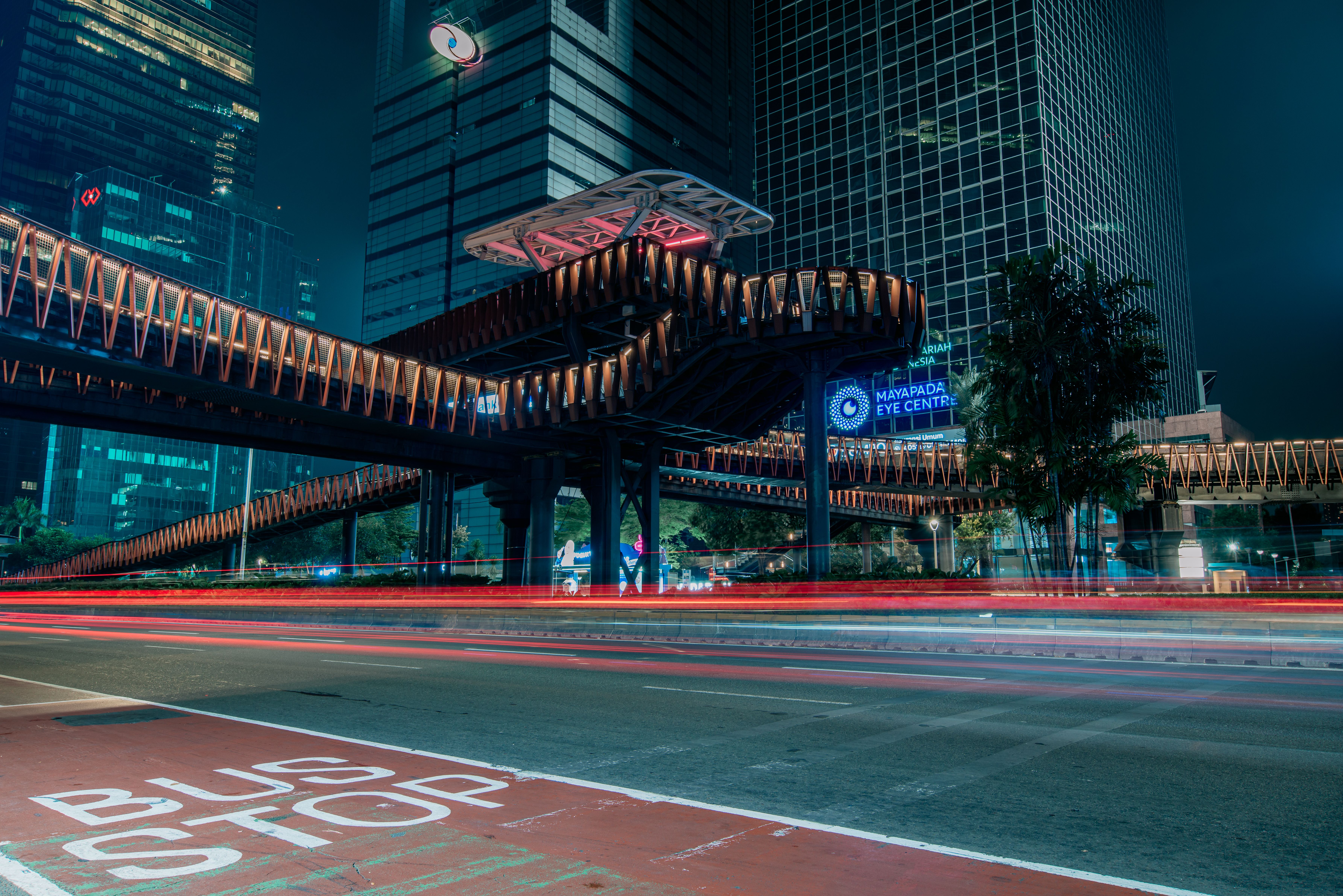 Dramatic nighttime skyline with illuminated buildings and motion light trails.