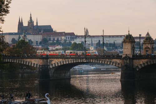 Free Breathtaking view of Prague Castle with a historic bridge and river in foreground, under a serene sky. Stock Photo