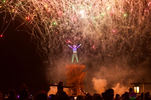Free Vibrant fireworks display over an illuminated structure during the iconic Burning Man event. Stock Photo