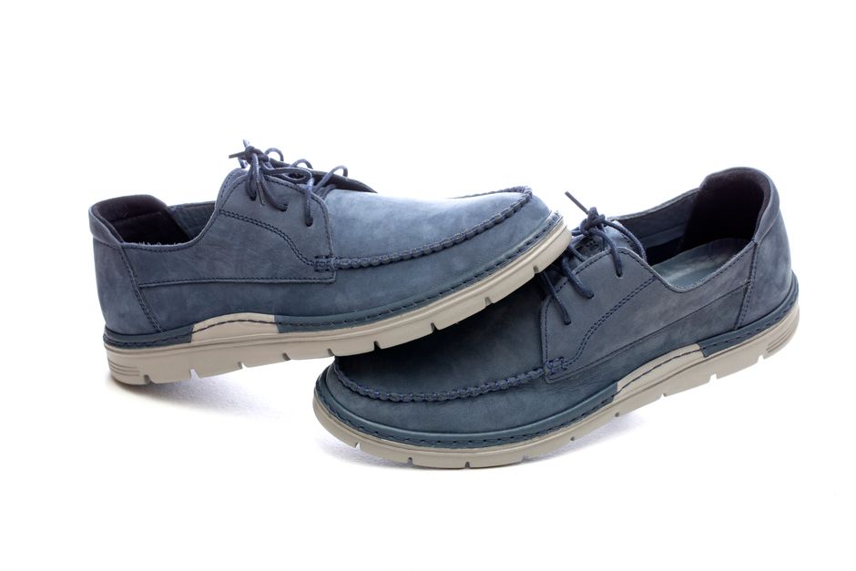Fotomural Par de mocasines de piel azul con cordones sobre fondo blanco, calzado informal moderno.