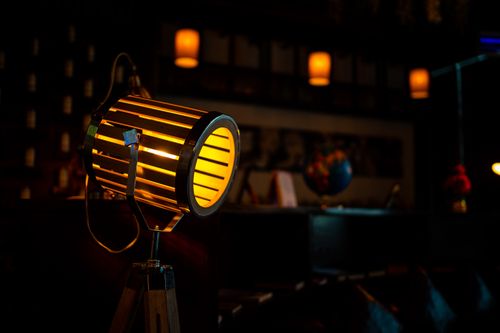 Free Vintage-style spotlight illuminating a dimly lit interior with a warm glow, creating an atmospheric ambience. Stock Photo