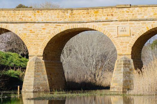 Richmond Bridge, built in 1823, reflects in the river below in Tasmania, Australia.