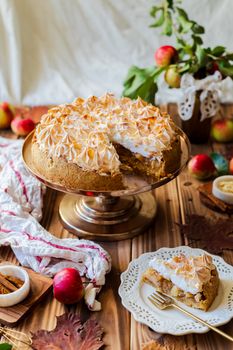 A beautifully arranged apple meringue pie on a wooden table, perfect for fall.