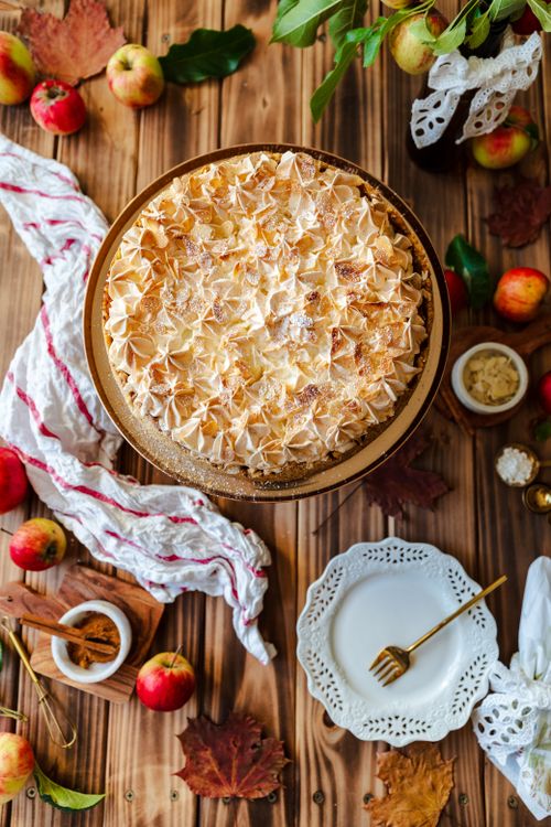 Free Top view of homemade apple pie surrounded by autumn elements like apples and leaves on a rustic wooden table. Stock Photo