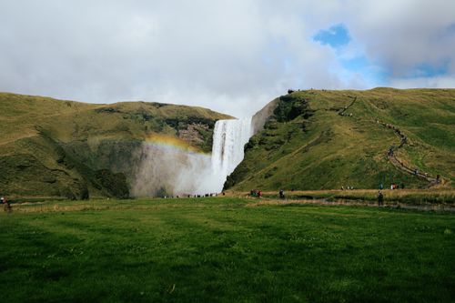 Free Explore the iconic Skogafoss waterfall with vibrant landscapes and a rainbow in Iceland. Stock Photo