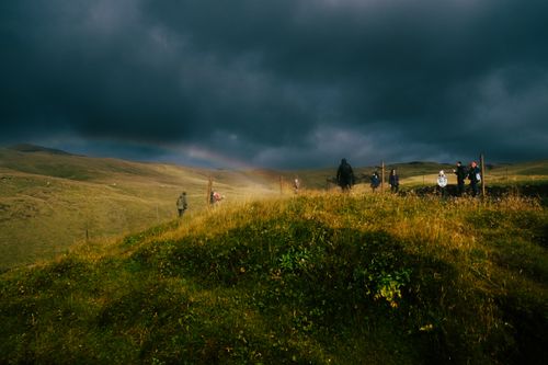 Free Hikers exploring the lush landscapes near Skogafoss in Rangárþing eystra, Iceland during fall. Stock Photo