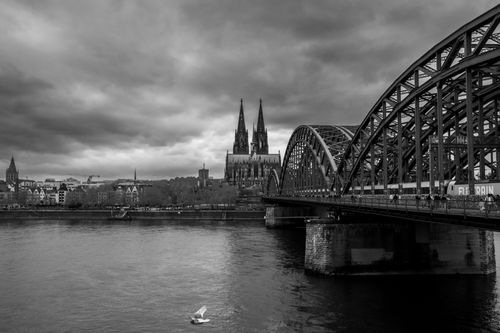 Free Stunning black and white view of Cologne Cathedral and Hohenzollern Bridge over the Rhine River. Stock Photo