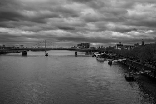 Free Black and white photo of Cologne riverside with dramatic clouds and bridge. Stock Photo