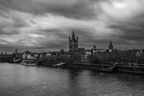 Free Black and white photo of Cologne's skyline featuring Great St. Martin Church under cloudy skies. Stock Photo