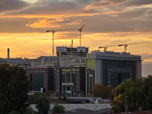 Free Urban construction site with cranes at sunset, showcasing modern architecture. Stock Photo
