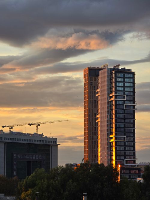 Free High-rise buildings and construction cranes during a vibrant sunset. Stock Photo