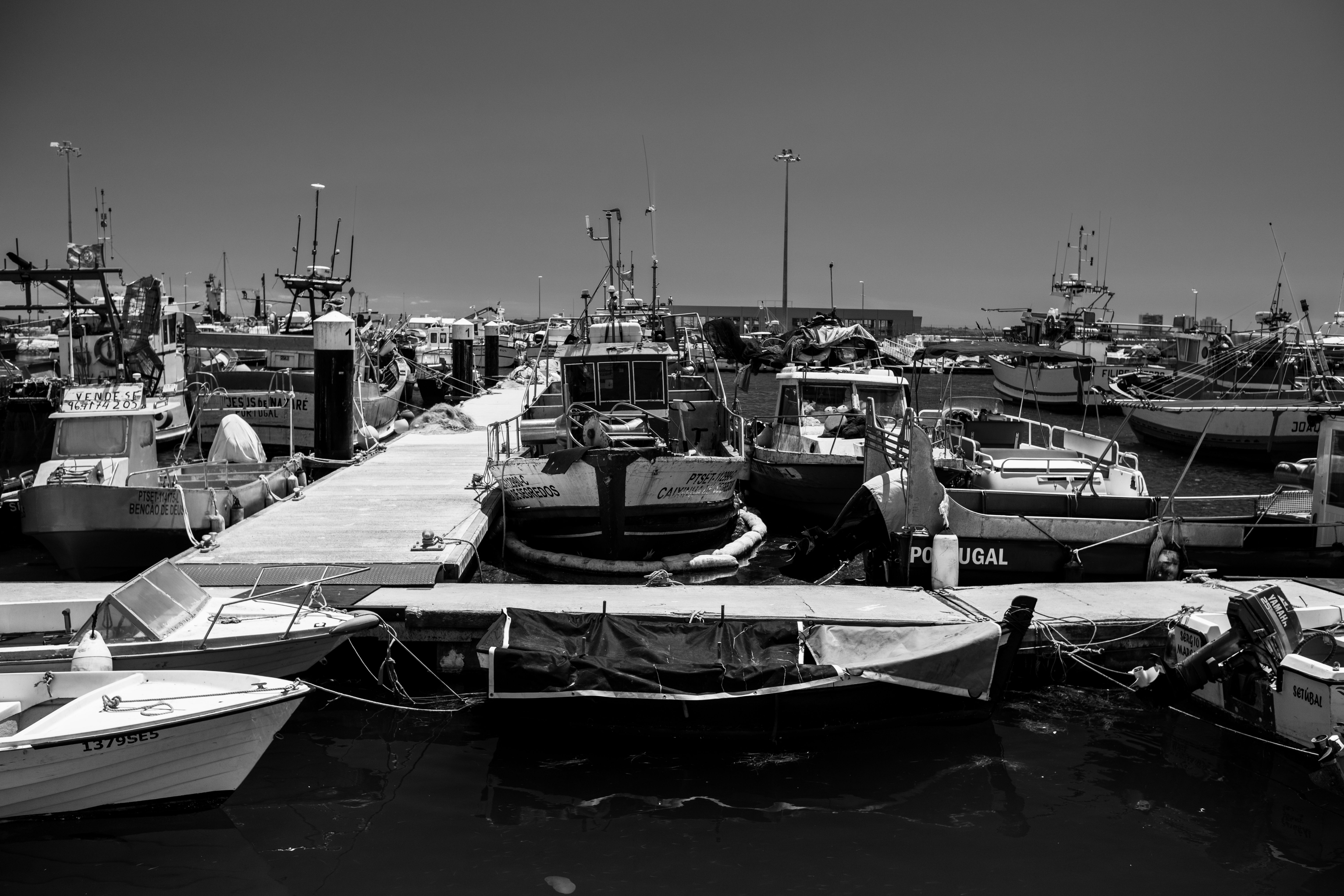 Monochrome image of fishing boats docked at Setúbal harbor, Portugal.