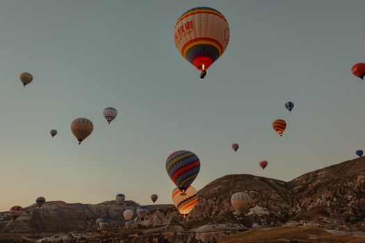 Stunning view of colorful hot air balloons rising over the unique landscapes of Cappadocia, Turkey.