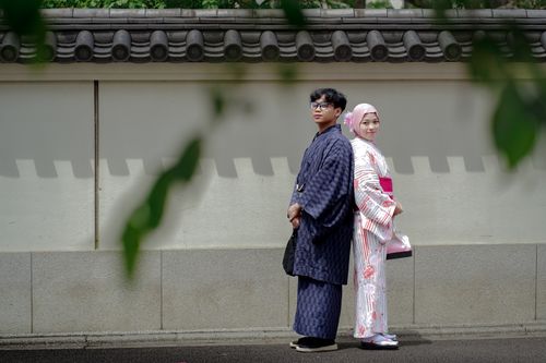 Free A couple wearing traditional kimonos in front of a Japanese wall in Tokyo. Stock Photo