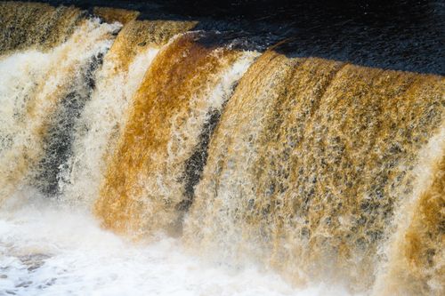 Free Dramatic capture of autumn-colored rapids cascading in a flowing river, creating natural patterns. Stock Photo