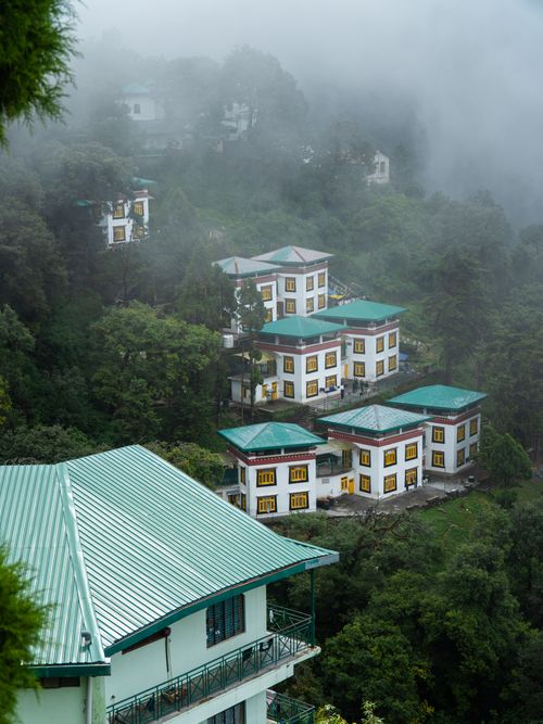 Free Charming houses nestled in foggy green hills of Mussoorie, Uttarakhand, India. Stock Photo