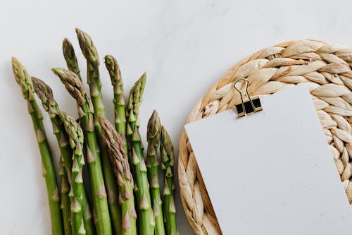Asparagus pods with paper sheet on table