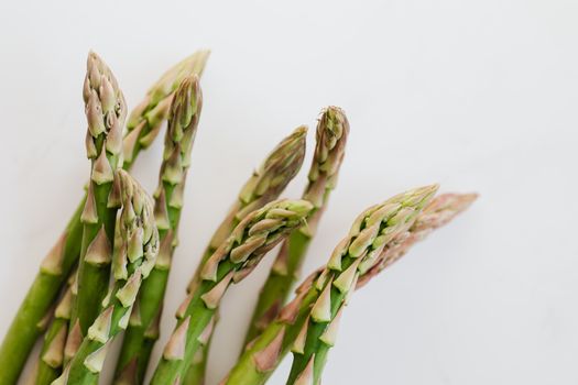 Close up bunch of fresh ripe asparagus in front of white smooth background