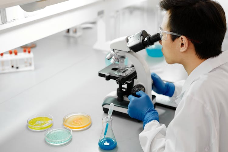 Man Using A Microscope Inside The Laboratory