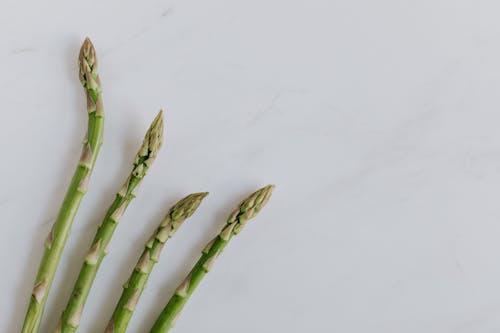 Four Stalks Of Asparagus On Marble Surface