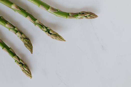 白色背景上，新鲜芦笋的特写镜头突出了其新鲜感和健康饮食的主题