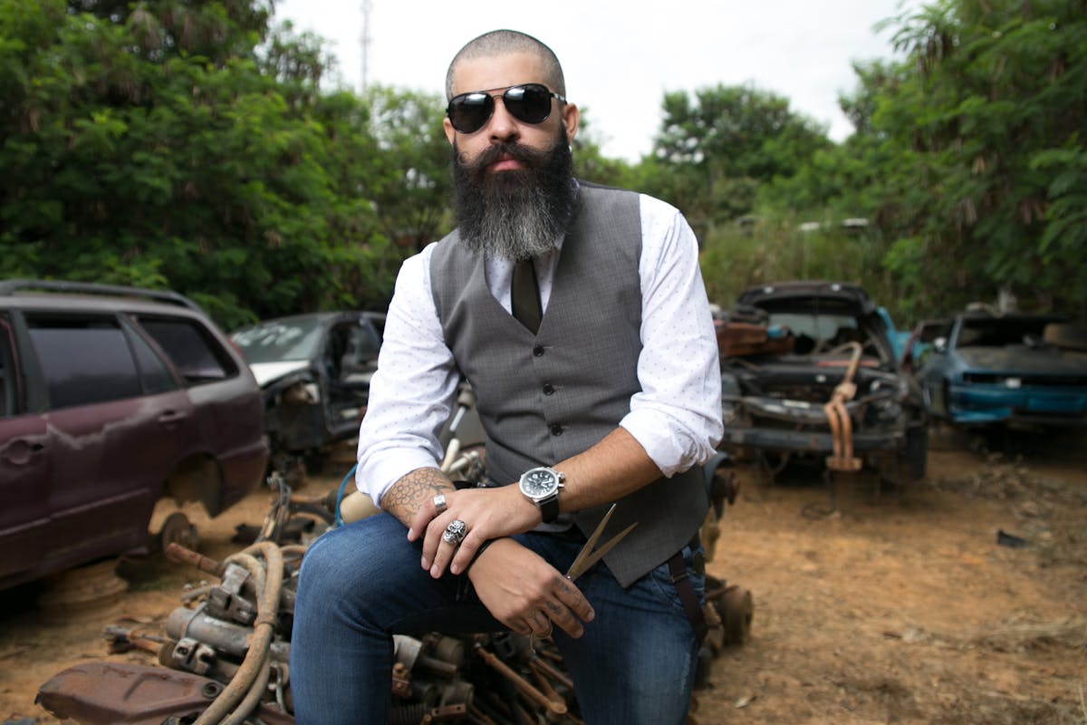 Person reading a newspaper horoscope section while holding a cup of coffee