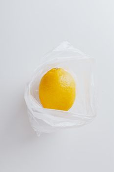 单个柠檬被装在透明的白色塑料袋里，以突出其新鲜感