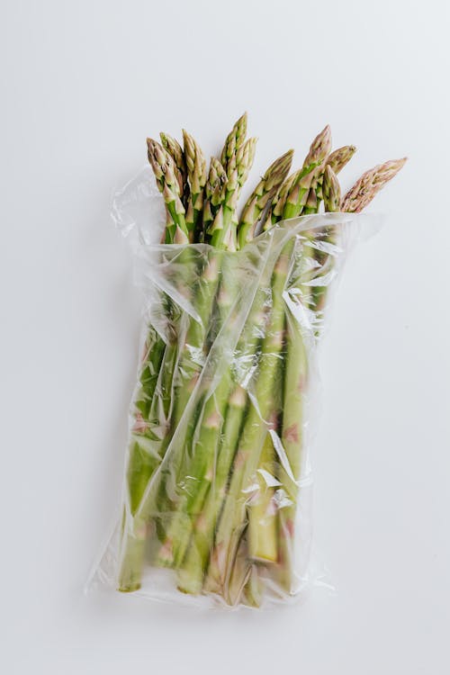 Asparagus stems in polyethylene bag isolated on white background