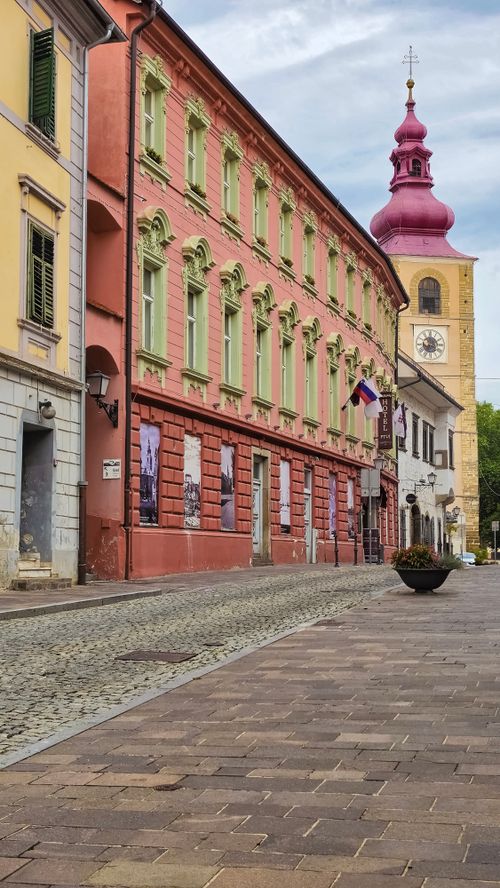 Free Picturesque street with colorful historical architecture and clock tower in Ptuj, Slovenia. Stock Photo