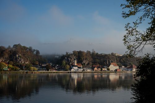 Free Beautiful autumn scenery of a lakeside village surrounded by hills and mist in Austria. Stock Photo