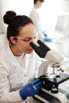 女科学家在实验室用显微镜检查标本