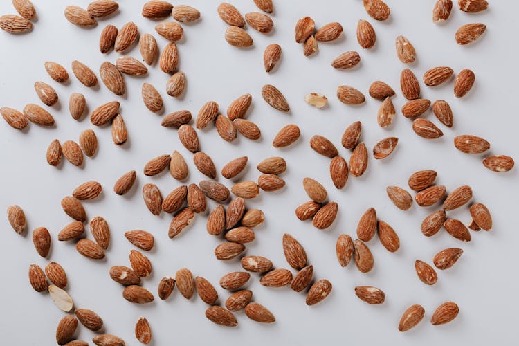 Scattered Almonds Placed On White Background