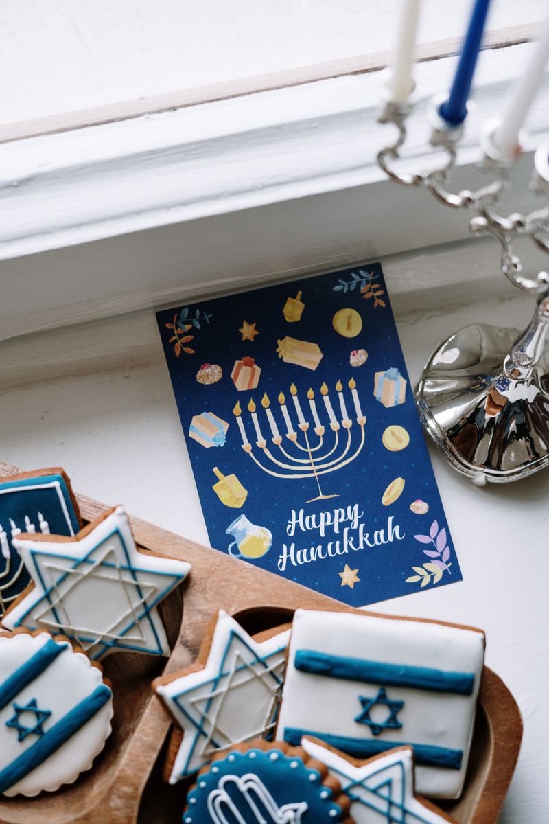 A close-up of traditional Hanukkah cookies with a menorah and festive card.