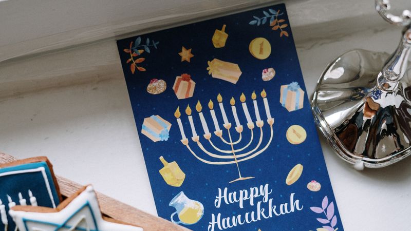 A close-up of traditional Hanukkah cookies with a menorah and festive card.