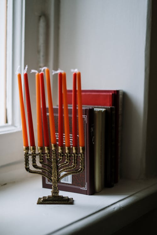 Menorah and Books Next to a Window