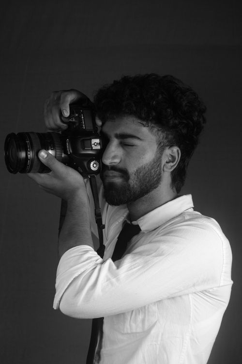 Free Black and white portrait of a photographer holding a camera to his eye. Stock Photo