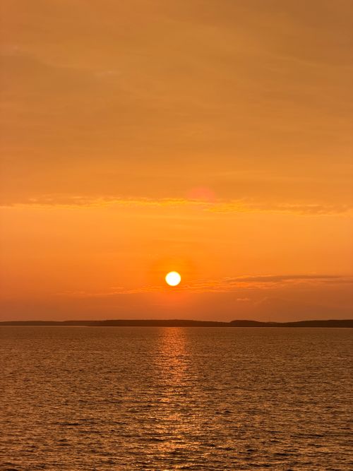 Free Stunning orange sunset over calm sea in Vietnam, evoking warmth and serenity. Stock Photo