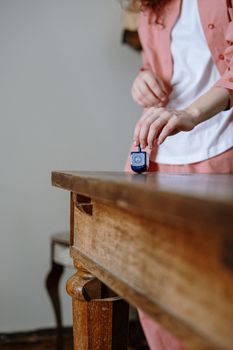 A person spins a dreidel on a wooden table, capturing a Hanukkah tradition.