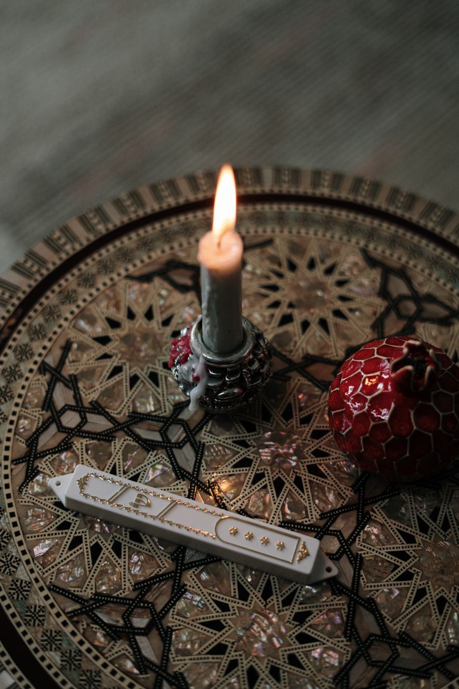 Mezuzah case beside a lit candle