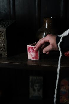 室内架子上，一只握着20以色列谢克尔钞票的手的特写